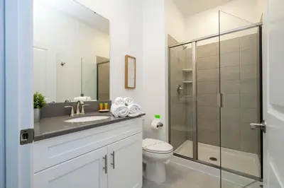 a bathroom with a toilet and a glass shower at Fantastic 4 Bd w Pool at Storey Lake Resort 2709 in Kissimmee
