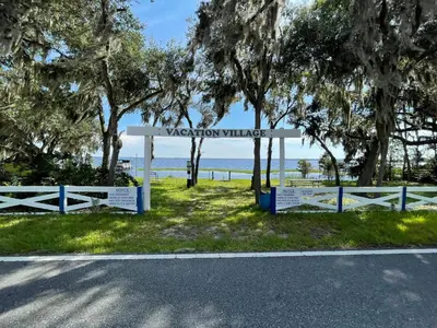 a sign for a vacation village on the side of a road at Watch the Sunrise on Lake Louisa in Clermont