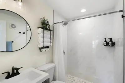 a white bathroom with a shower and a sink at Watch the Sunrise on Lake Louisa in Clermont