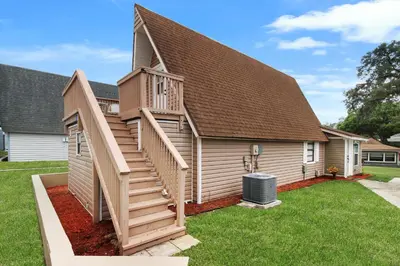 a house with a wooden staircase leading up to a house at Watch the Sunrise on Lake Louisa in Clermont
