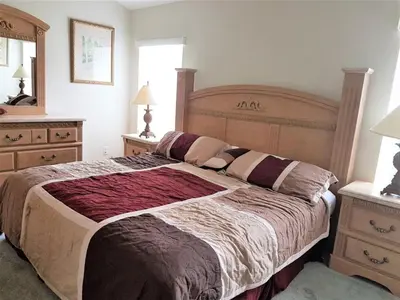 a bedroom with a large bed and two dressers at Captain Jack's Getaway in Kissimmee