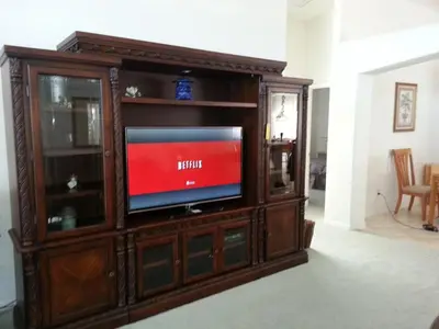 a wooden entertainment center with a television in it at Captain Jack's Getaway in Kissimmee