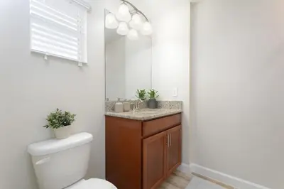 a bathroom with a toilet and a sink with a mirror at Stunning Storey Lake Villa Prime Location in Kissimmee