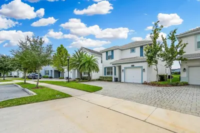 a large white house with a driveway at Luxury Storey Lake Retreat - Spacious Disney-Near in Kissimmee