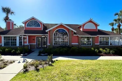 a red house with a palm tree at Cozivill in Kissimmee