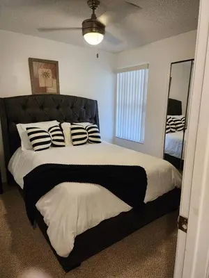 a bedroom with a large bed with black and white pillows at Cozivill in Kissimmee