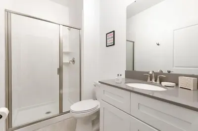 a white bathroom with a toilet and a shower at Charming Mickey-Themed Home Prime Location in Kissimmee