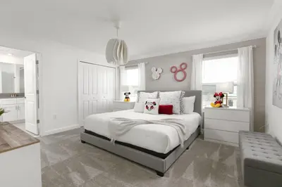 a white bedroom with a large bed and a kitchen at Charming Mickey-Themed Home Prime Location in Kissimmee