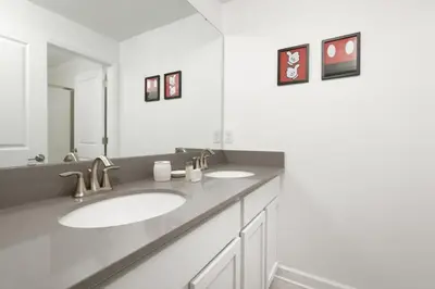 a bathroom with two sinks and a large mirror at Charming Mickey-Themed Home Prime Location in Kissimmee