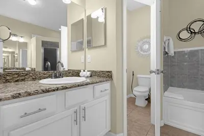 a bathroom with a sink and a toilet at Luxury 4BR Home - Private Pool BBQ - Near Disney in Kissimmee