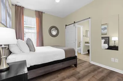 a bedroom with a bed and a large window at Luxury 4BR Home - Private Pool BBQ - Near Disney in Kissimmee