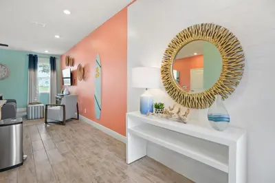 a living room with a mirror on the wall at Surfstyle at Margaritaville by Shine Villas 022 villa in Orlando