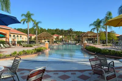 a swimming pool at a resort with chairs and an umbrella at 1320 - Aladin Cozy Bella Vida Kissimmee Close Disney in Kissimmee
