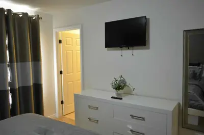 a bedroom with a dresser with a television on a wall at 1320 - Aladin Cozy Bella Vida Kissimmee Close Disney in Kissimmee