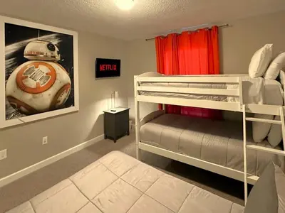 a bedroom with two bunk beds and a football picture at Charming 4BR with Private Heated Pool & BBQ Grill in Kissimmee