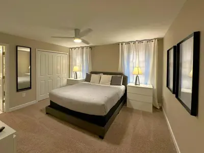 a bedroom with a bed with two night stands and two lamps at Charming 4BR with Private Heated Pool & BBQ Grill in Kissimmee