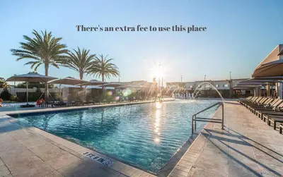 a large swimming pool with palm trees in the background at Elegant Home w 3 En Suites & Breathtaking View in Orlando
