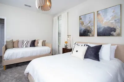 a white bedroom with two beds and a couch at Stunning 5BR Home - Your Dream Getaway in Kissimmee
