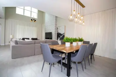 a dining room with a table and chairs and a couch at Stunning 5BR Home - Your Dream Getaway in Kissimmee