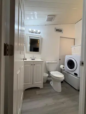a bathroom with a toilet and a sink and a microwave at 15 min to Disney World, Self-check-in, Full Kitchen in Kissimmee