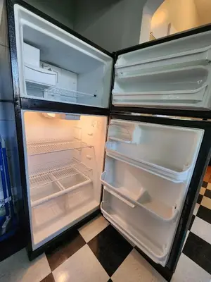 an empty refrigerator with its door open in a kitchen at Cozy Vintage Bungalow @Mills50 District in Orlando