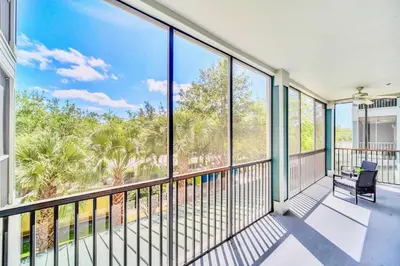a balcony with a chair and large windows at Near Disney - 2BR Condo Unit - Pool in Orlando