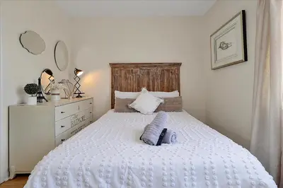a bedroom with a white bed and a dresser at Magical Serenity in Orlando