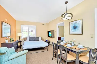 a living room with a bed and a dining room at 1BR Condo - Two Queens Arcade Pool - Near Disney in Orlando