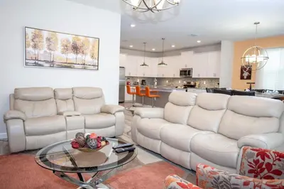 a living room with white couches and a glass table at Home 6BR - Prime Location in Kissimmee