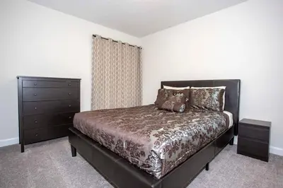 a bedroom with a large bed and a dresser at Home 6BR - Prime Location in Kissimmee