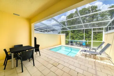 a house with a pool and a table and chairs at Ultimate Getaway - Your Best Vacation Home in Orlando