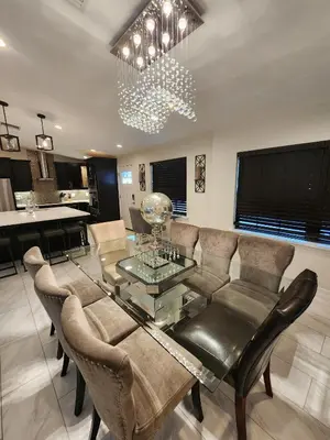 a living room with a glass table and chairs at The Villa Orlando College Park Sleeps16 - Monthly Stays in Orlando