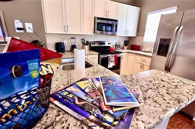 a kitchen with a counter with books on it at ABC Vacation Homes in Kissimmee