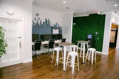 a waiting room with stools and a green wall at ABC Vacation Homes in Kissimmee