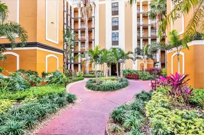 a walkway in front of a building with trees and plants at Cozy Orlando Resort Condo 4Mi from Disney in Orlando