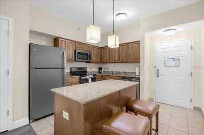 a kitchen with a refrigerator and a counter top at Cozy Orlando Resort Condo 4Mi from Disney in Orlando