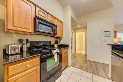 a kitchen with a stove and a microwave at Exquisite 3 Bdr Condo Minutes to Disney in Orlando