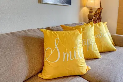a couple of yellow pillows on a bed at Exquisite 3 Bdr Condo Minutes to Disney in Orlando
