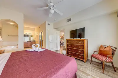 a bedroom with a bed and a dresser and a chair at Exquisite 3 Bdr Condo Minutes to Disney in Orlando