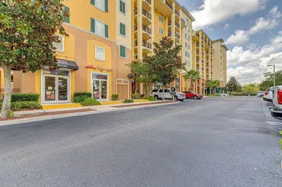 a city street with a yellow building and cars parked at Exquisite 3 Bdr Condo Minutes to Disney in Orlando