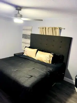 a bedroom with a black bed with yellow pillows at 3brdrm home near Downtown Orlando and Winterpark in Orlando