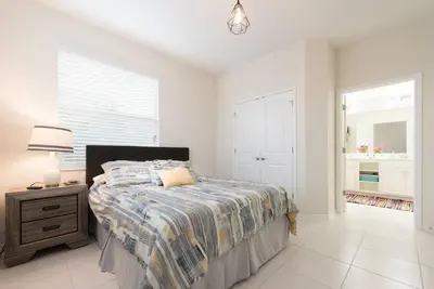 a bedroom with a bed and a lamp and a window at Apartment 3BR Great Location - Super Comfort in Kissimmee