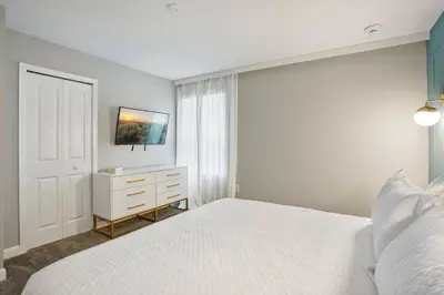 a white bedroom with a white bed and a window at New Home 8 Bedrooms and 5 Bathrooms At Storey Lake in Kissimmee