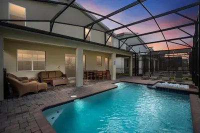 a house with a swimming pool with a glass roof at New Home 8 Bedrooms and 5 Bathrooms At Storey Lake in Kissimmee
