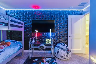 a bedroom with a bed and a blue wall at Family Retreat near Disney with Pool & Hot Tub! in Kissimmee