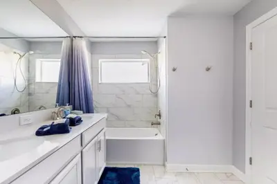 a white bathroom with a tub and a sink at Family Retreat near Disney with Pool & Hot Tub! in Kissimmee