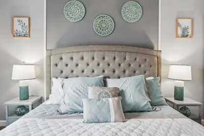 a bedroom with a bed with pillows and plates on the wall at Family Retreat near Disney with Pool & Hot Tub! in Kissimmee