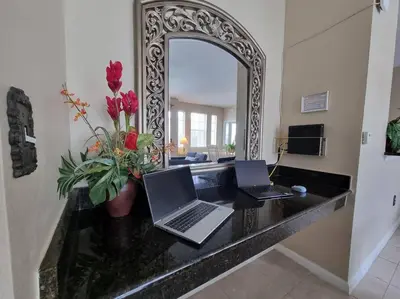 two laptops on a counter in a room with a mirror at Comfortable Apartment, Close to Disney World in Kissimmee