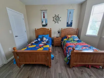 a bedroom with two beds and a clock on the wall at Comfortable Apartment, Close to Disney World in Kissimmee