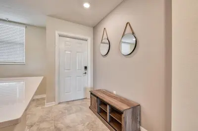 a room with a table and mirrors on the wall at Modern Luxe Condo - Stunning Design in Kissimmee